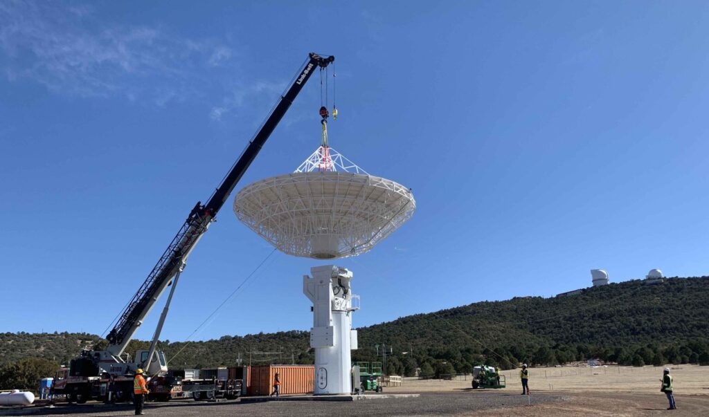 Antenna being lowered on to antenna tower.